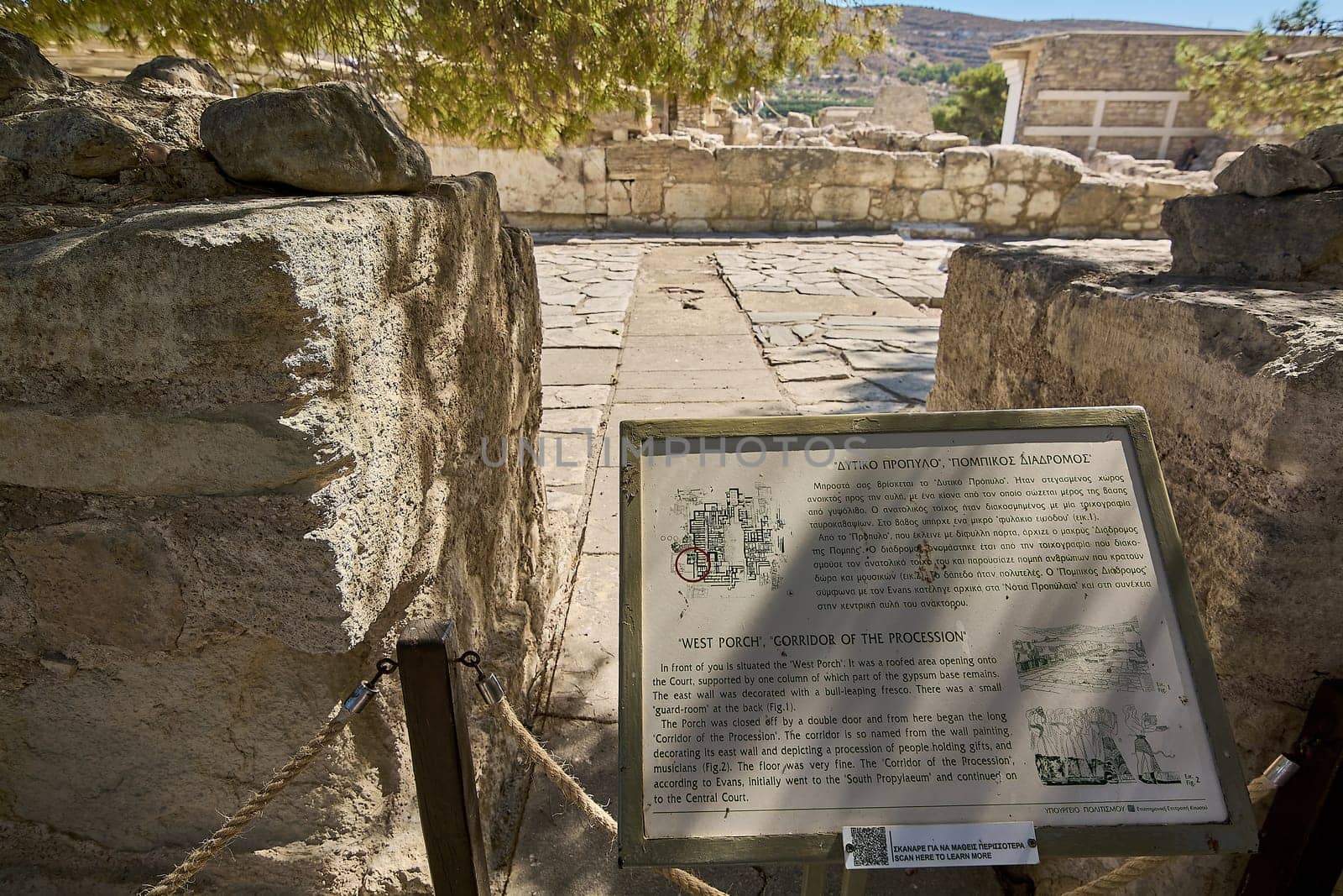 Informational plaque at Knossos, detailing the Corridor of the Procession and West Porch of the palace. The sign includes historical facts, site diagrams, and archaeological references.