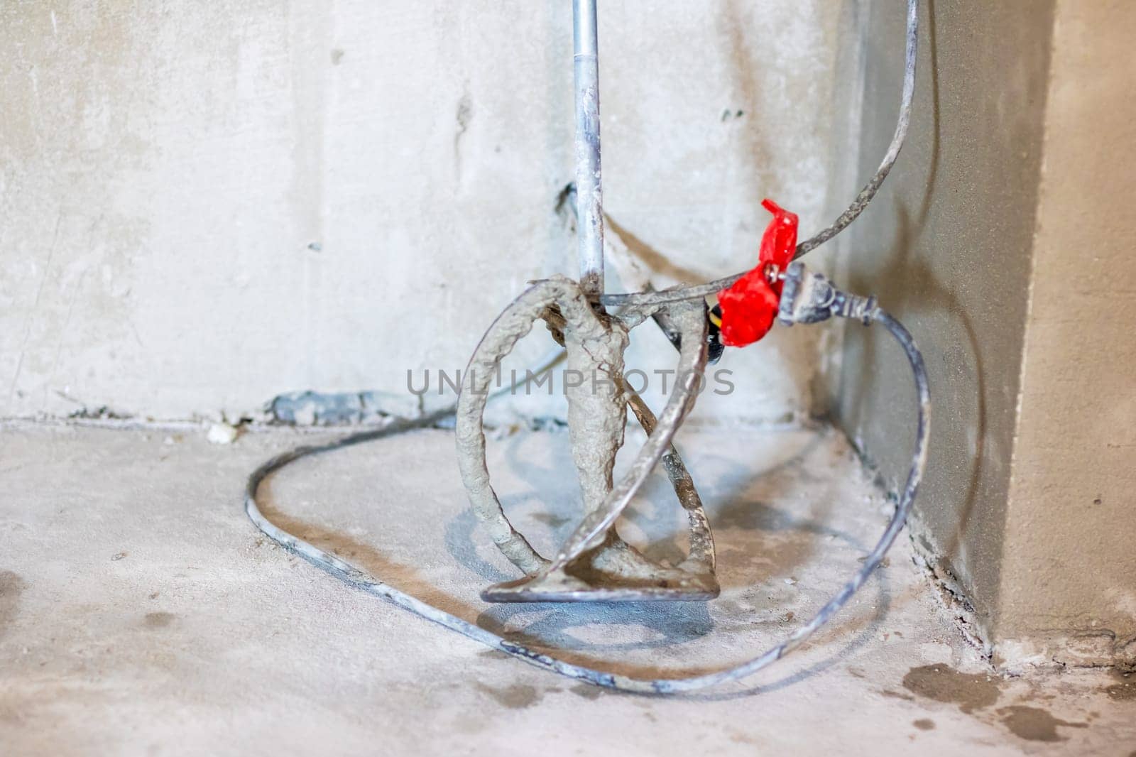 A vibrant hose featuring a bright red valve that is securely attached to it, contrasting its flexible form against its surroundings