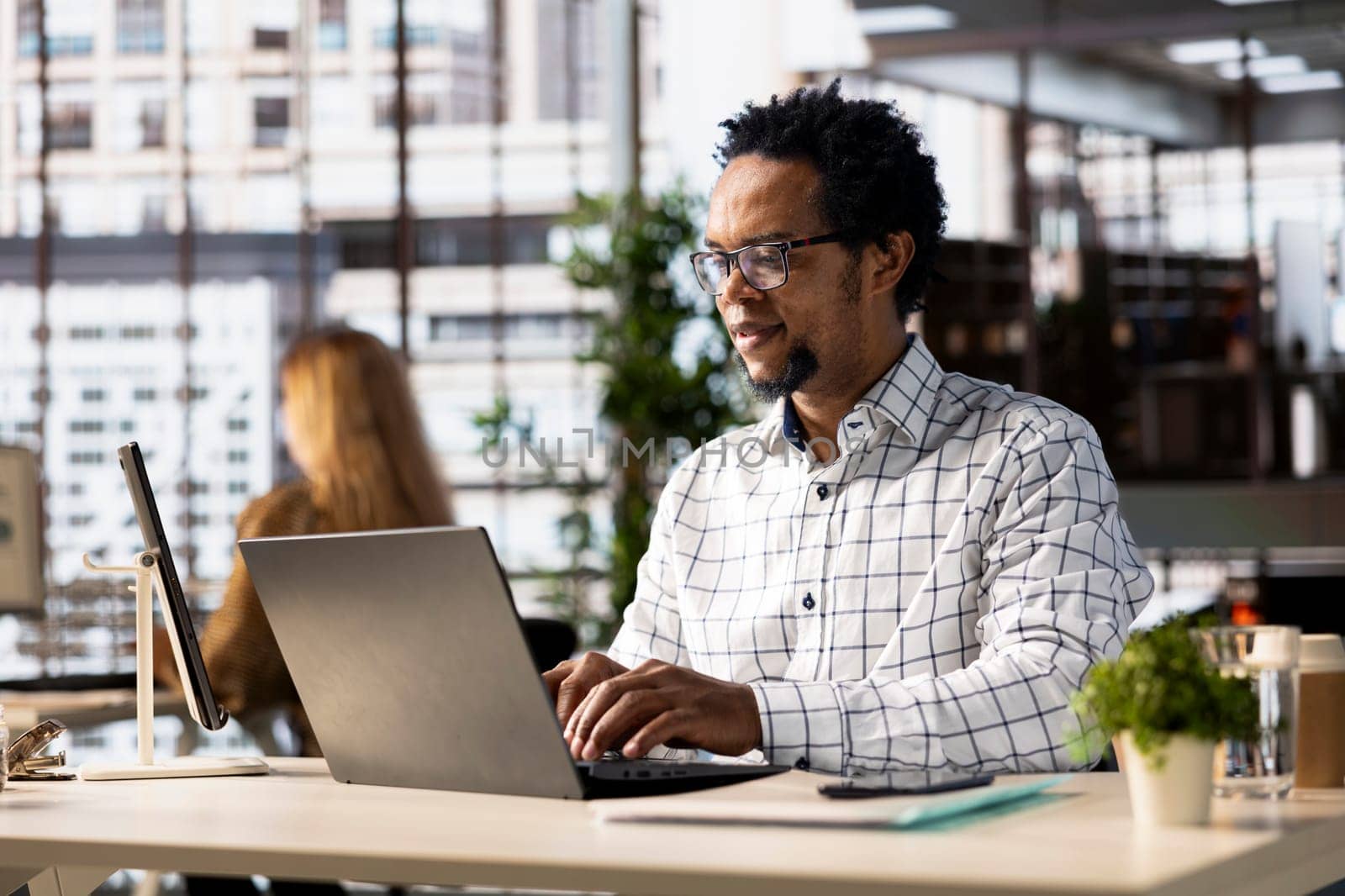 Confident businessman at his office desk working on report writing, financial planning and deadline management. Expert specialist reviewing objectives and goals to ensure success.