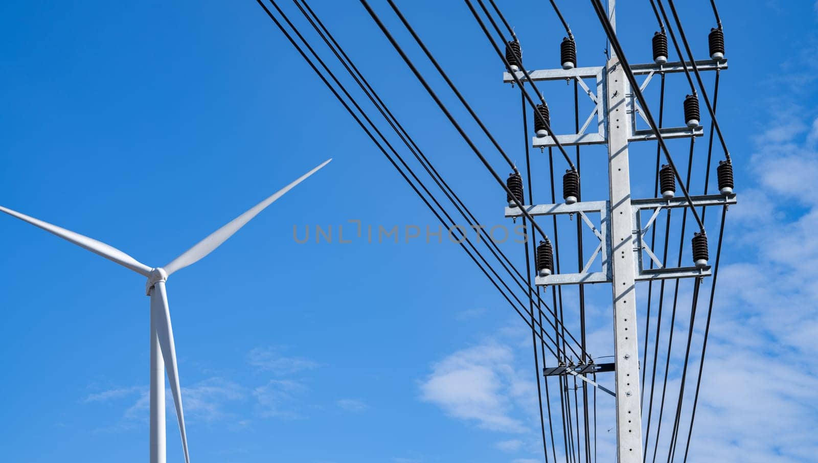 Electricity transmission pylon. Transmission tower collect electricity from wind turbines for sustainable energy. Clean power. Renewable energy infrastructure. Electricity high-voltage lines.