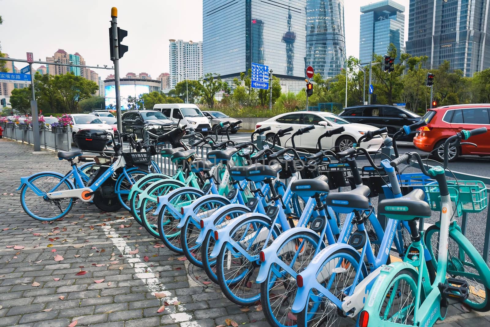 Shanghai, China - 1 April 2025: Rows of shared bicycles fill a parking area, highlighting Shanghai's green transport solutions amid urban traffic – promoting clean air and healthy urban living.