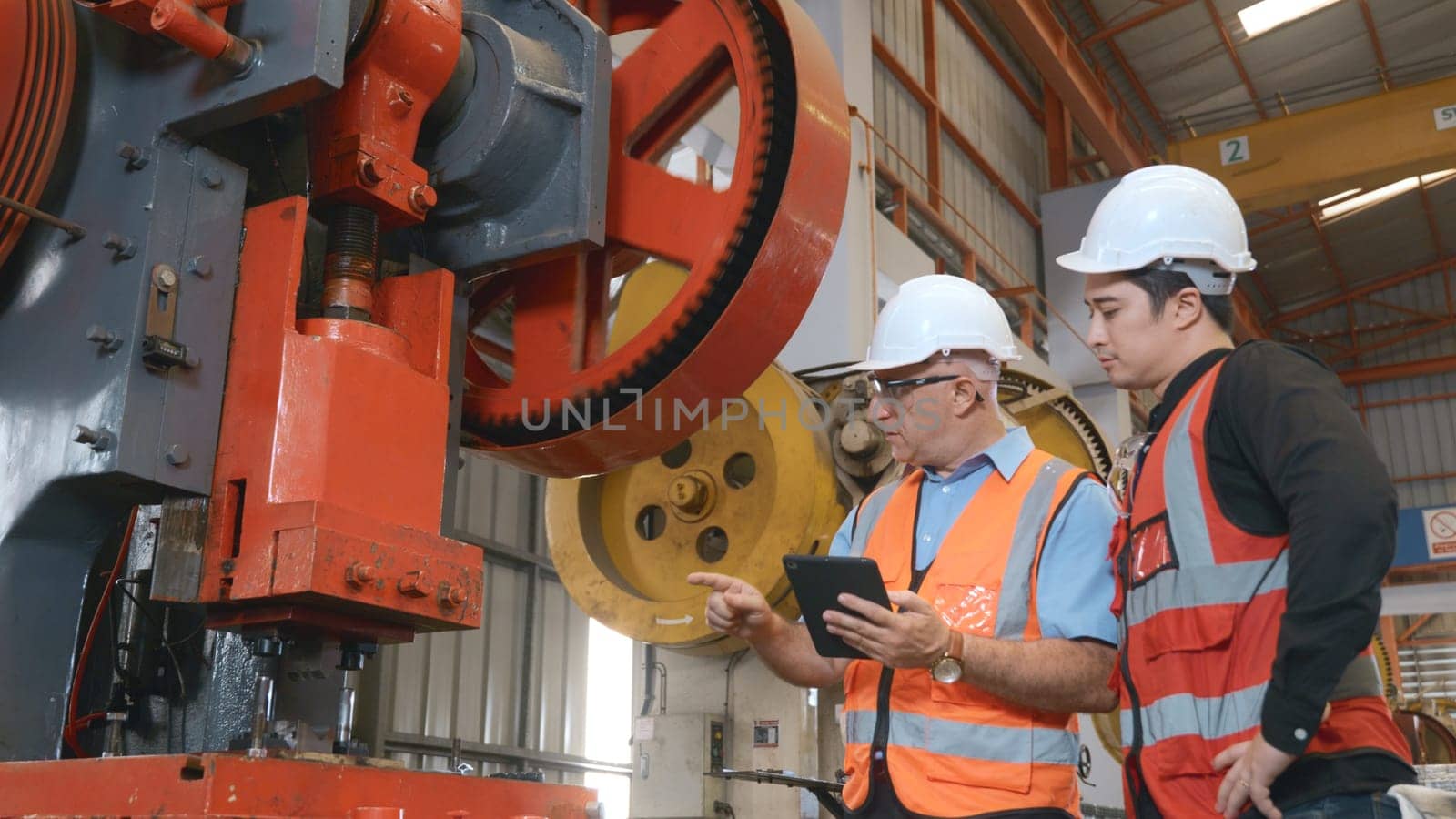 Two engineers talking together in roof steel metal manufacturing factory industry, engineering worker man standing explaining for maintain of metal sheet stamping machine, teamwork concept