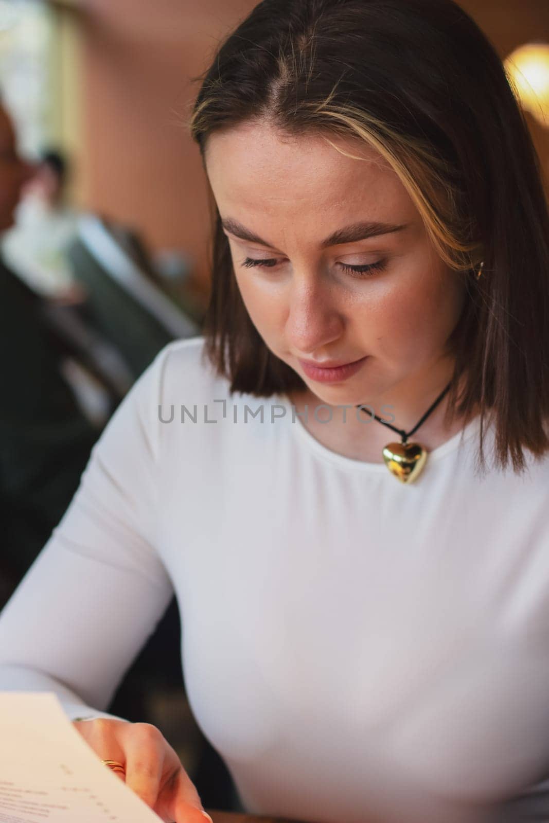 Young woman looking at the menu in a restaurant, beautiful brown-haired woman with short hair. High quality photo