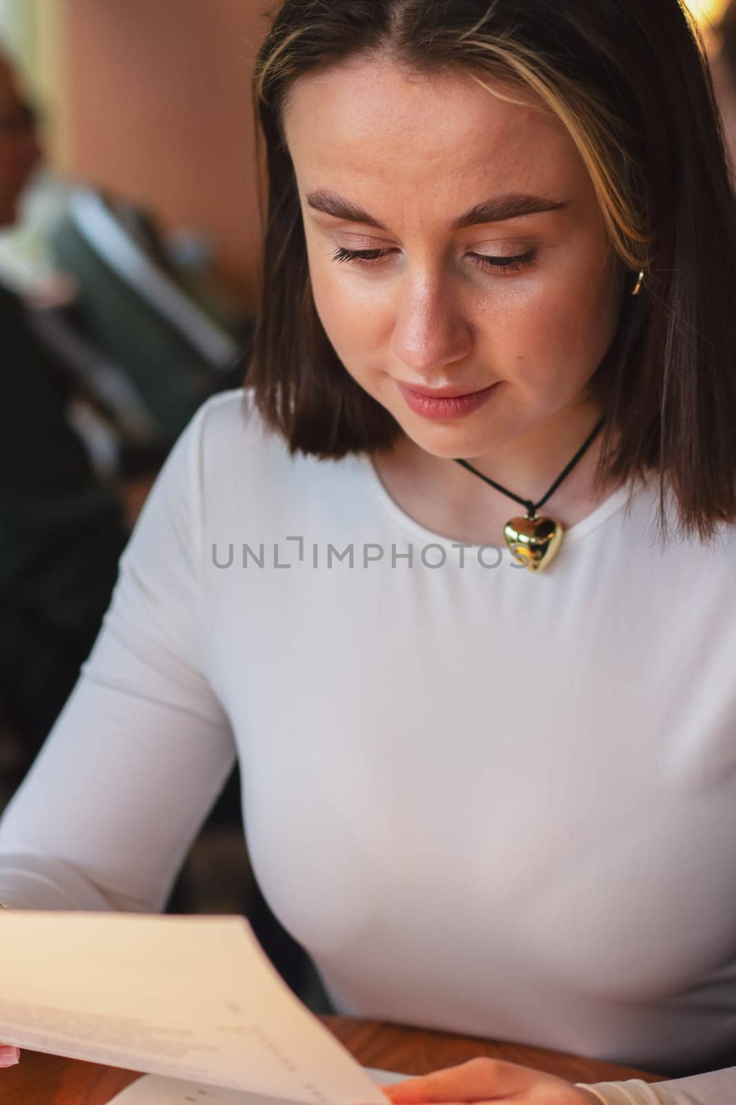 Young woman looking at the menu in a restaurant, beautiful brown-haired woman with short hair. High quality photo