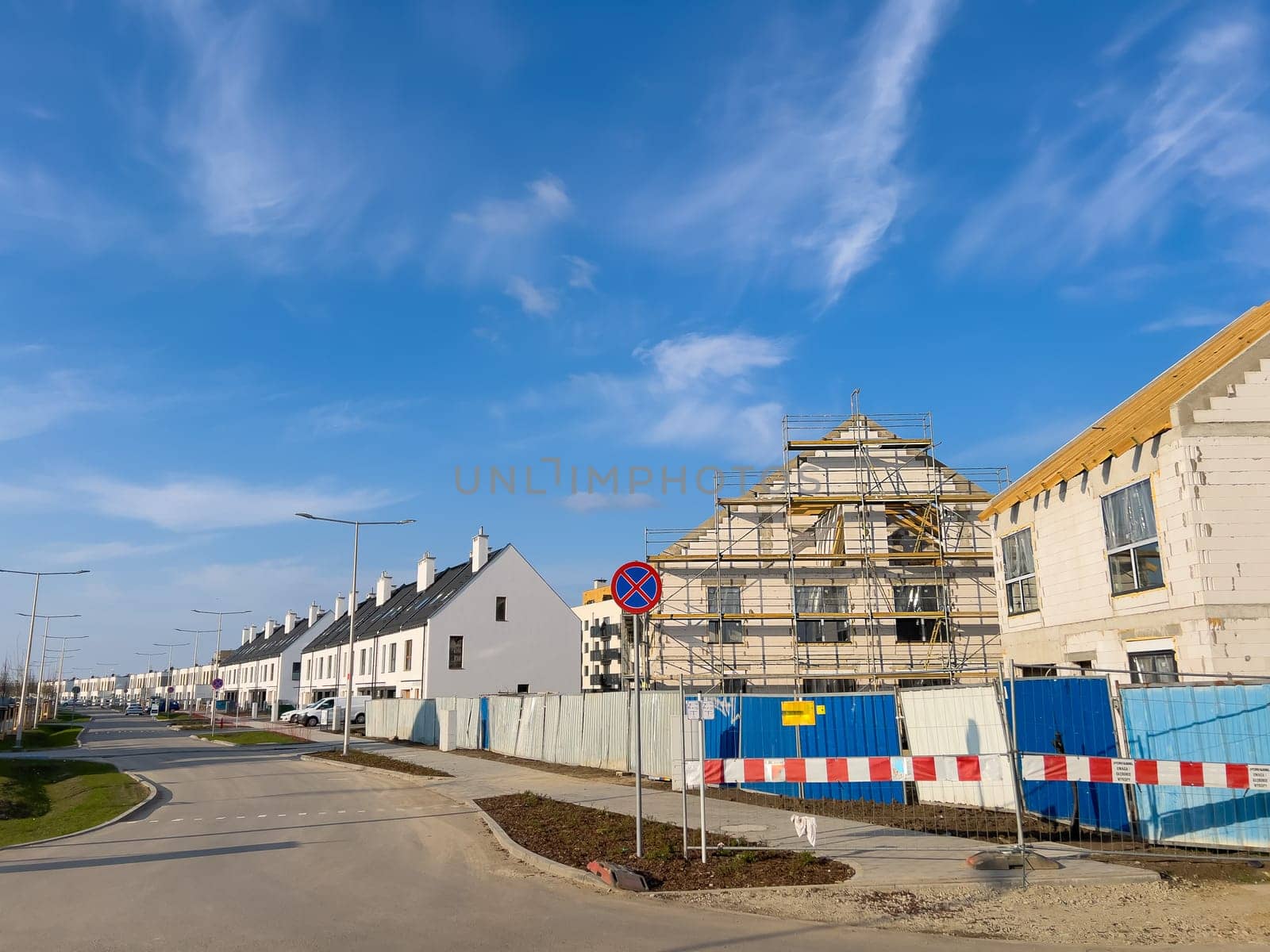 Unfinished new houses being built with white bricks in the city under a blue sky. High quality photo