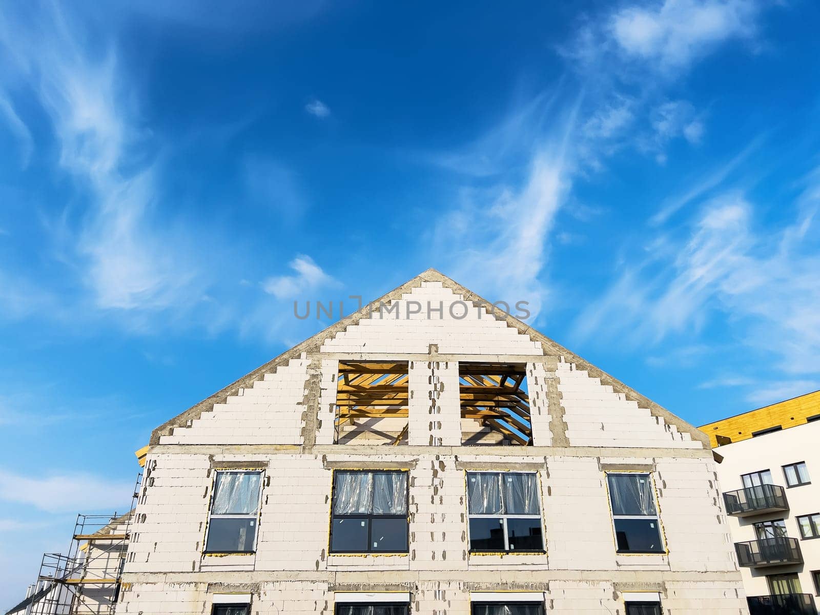 Unfinished new houses being built with white bricks in the city under a blue sky. High quality photo