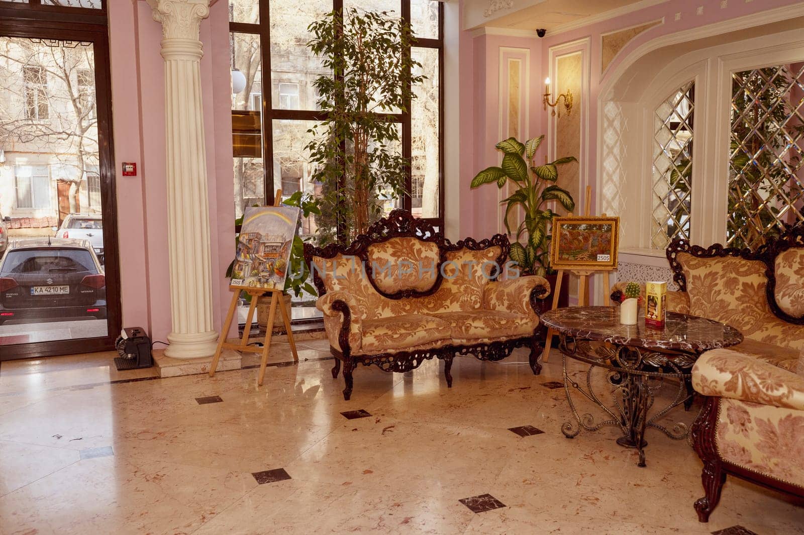 Odessa, Ukraine - February 26, 2025: California Hotel. Luxurious hotel lobby with large antique sofas, tables and armchairs in the lobby. Double-leaf sliding door. Interior design in red and gold tones