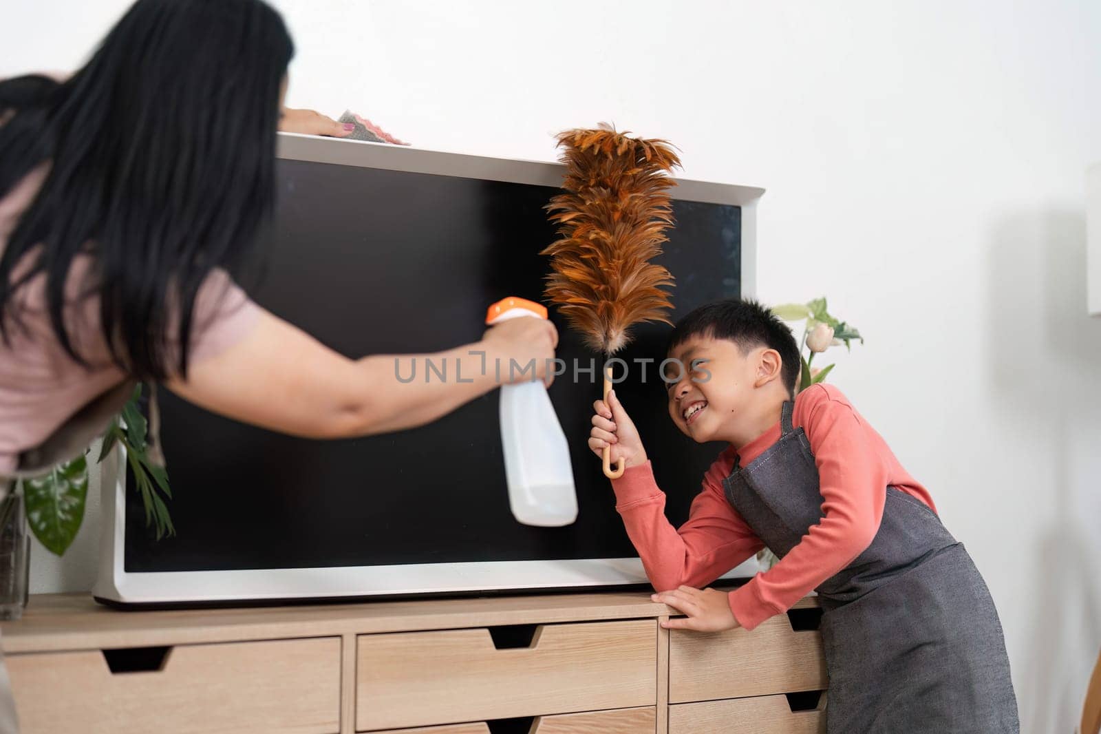 A joyful scene of a mother and her son engaging in house cleaning together, fostering teamwork and responsibility while maintaining a tidy home.