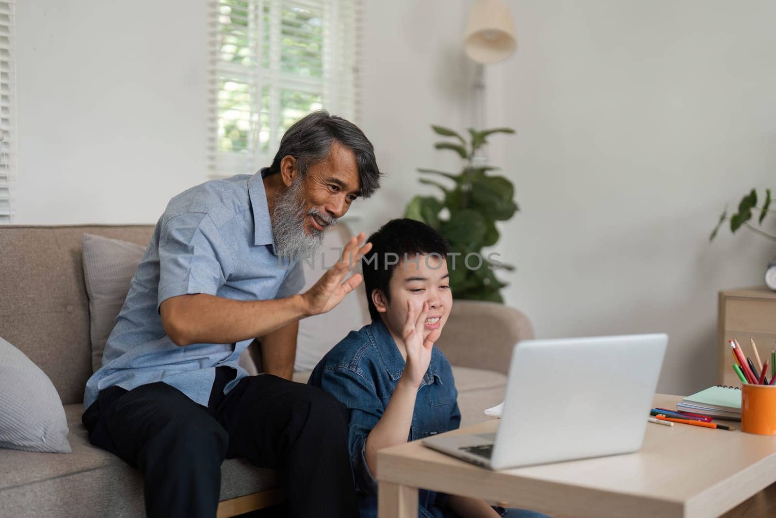 A warm moment between a grandfather and his grandson as they connect through a video call, showcasing the joy of family interaction and technology's role in communication.