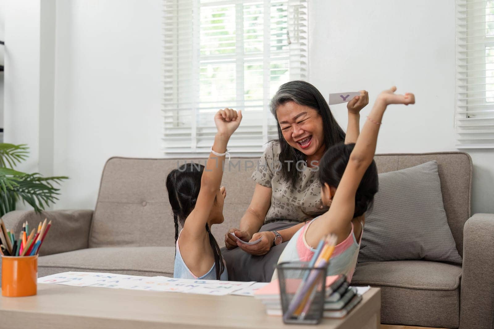 The grandmother joyfully engages with her granddaughters as they celebrate their artistic achievements, enhancing their learning experience together.
