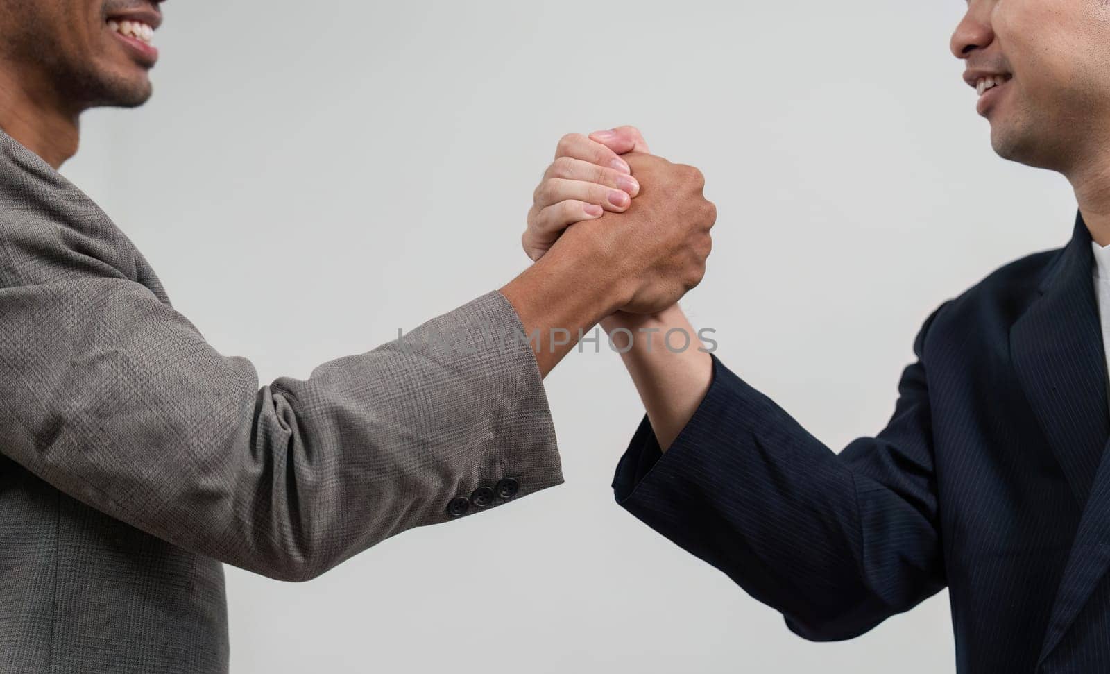 Two men shake hands, signifying a successful collaboration or agreement in a business context, showcasing professionalism and mutual respect.
