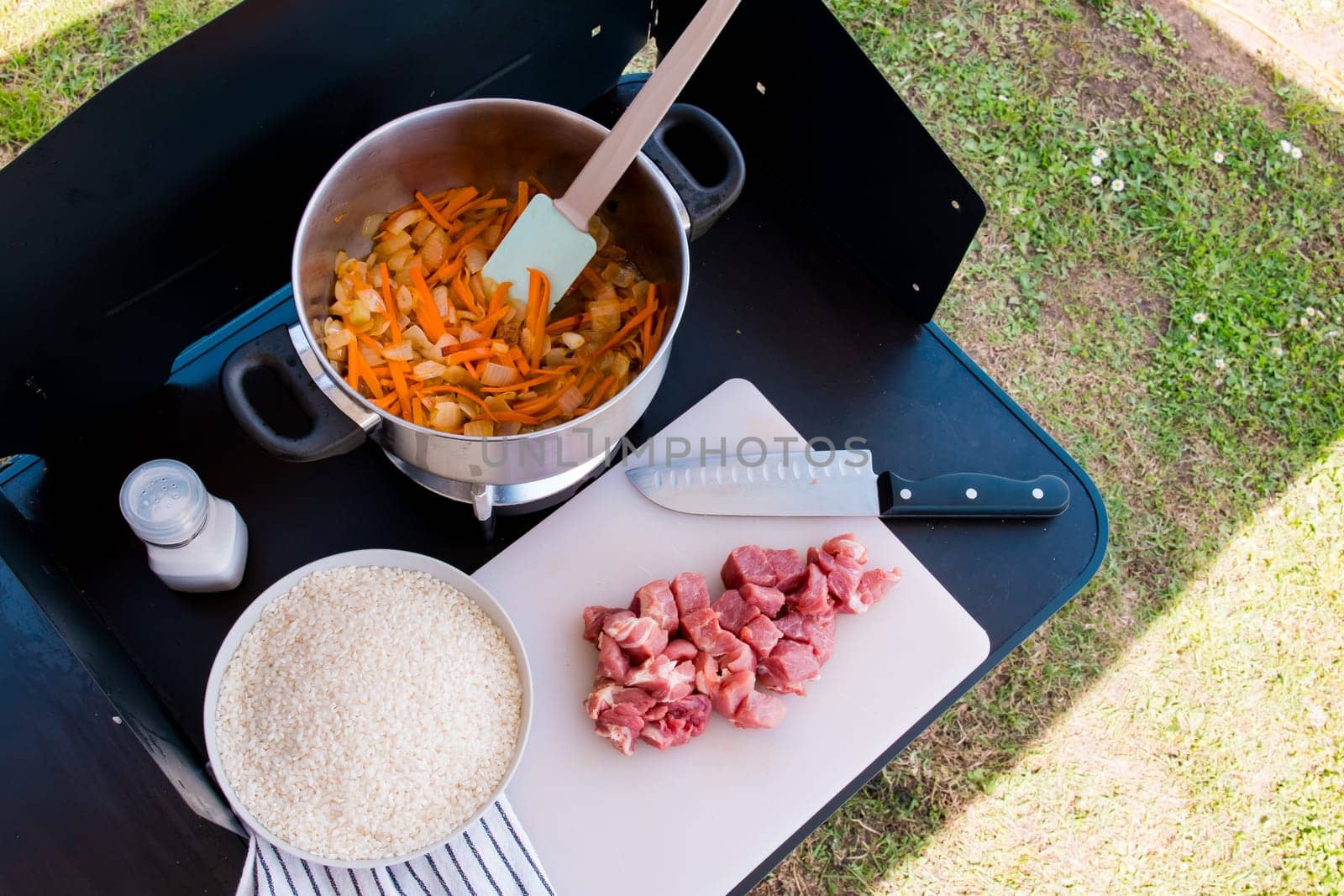 Outdoor cooking scene with ingredients for a savory meal on a sunny day.