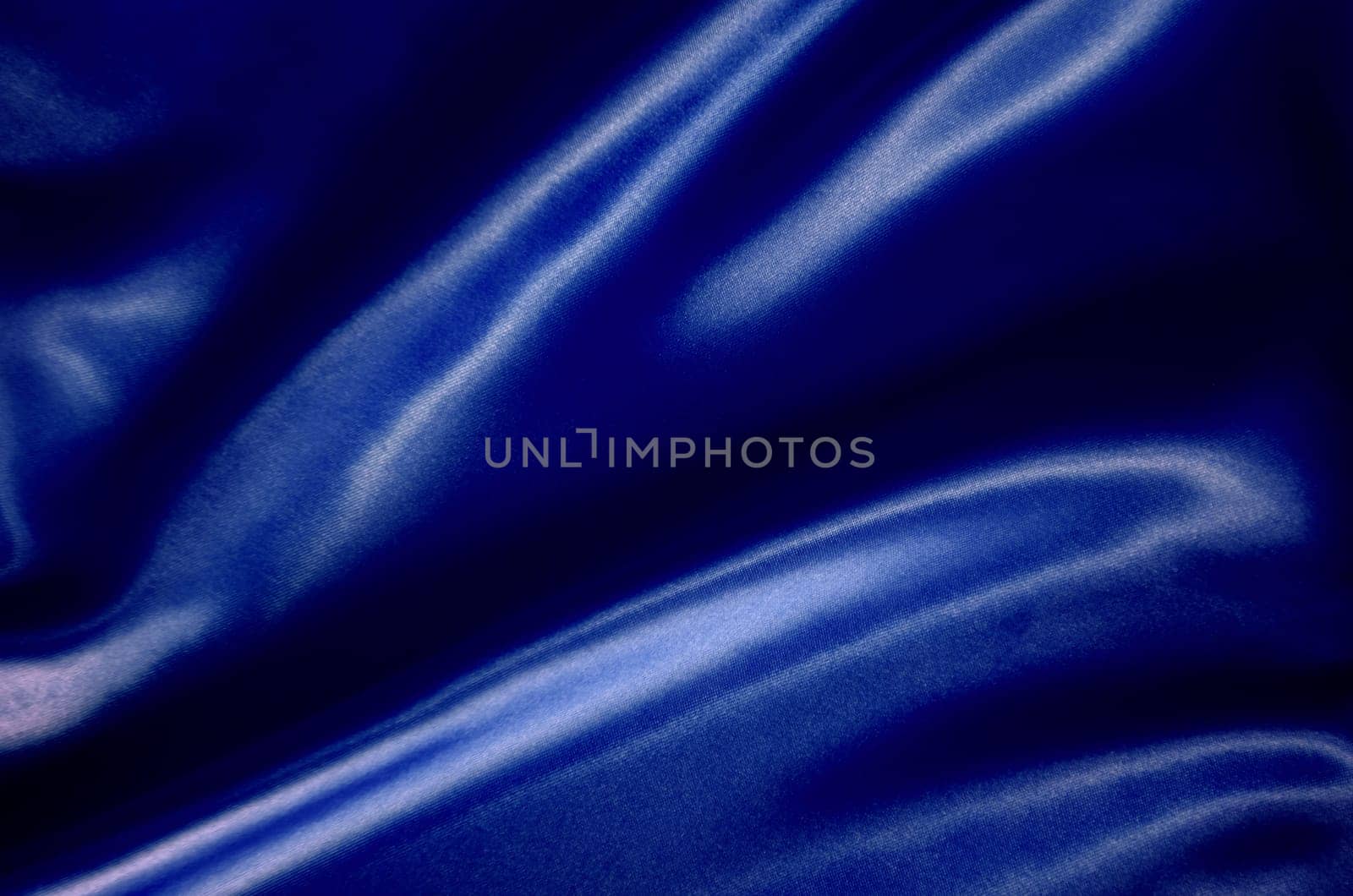 Top view of dark blue silk cloth with silky sheen suitable for design and wallpaper background.