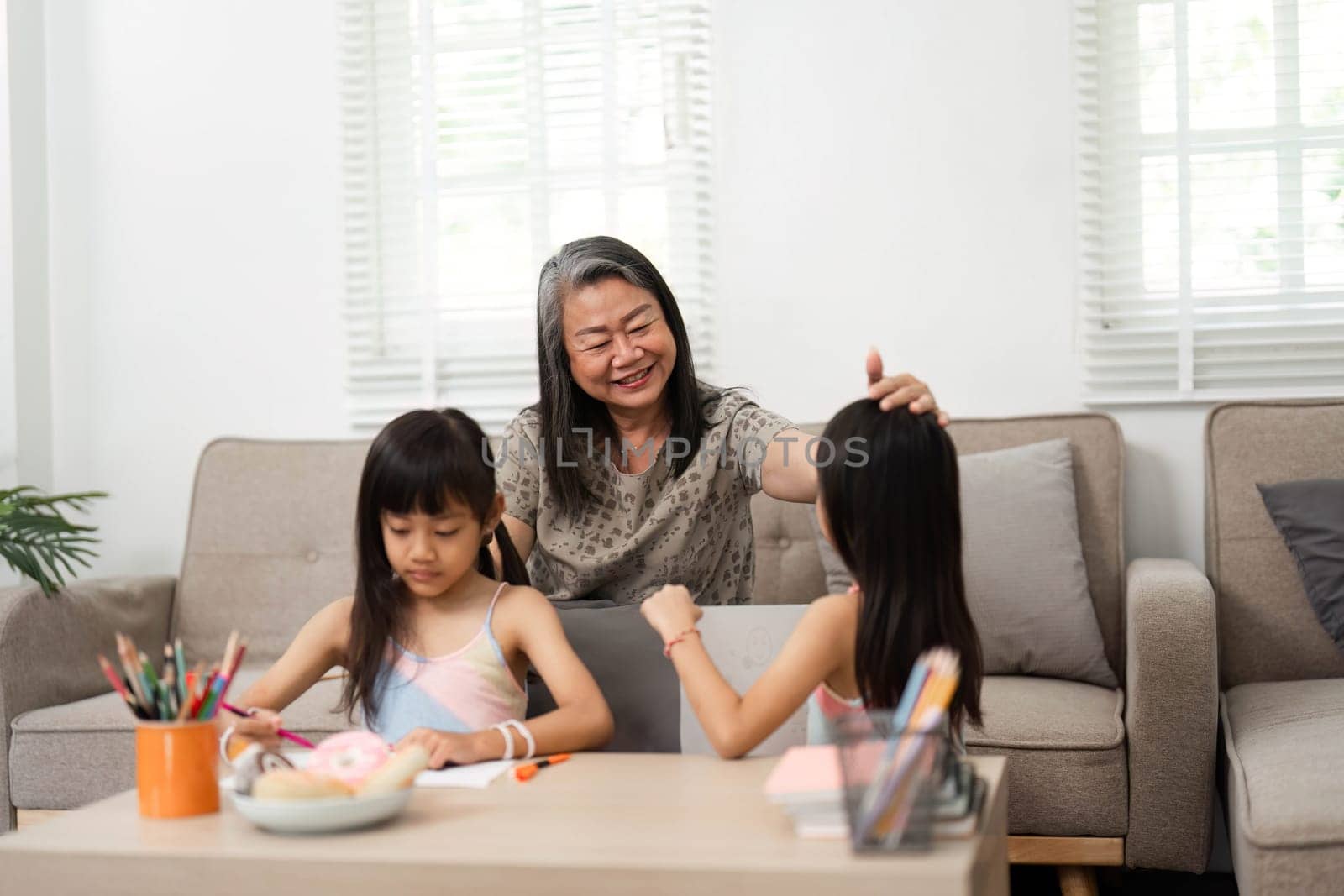 A loving grandmother engages her granddaughters in fun educational activities, fostering a joyful learning environment as they prepare for school.