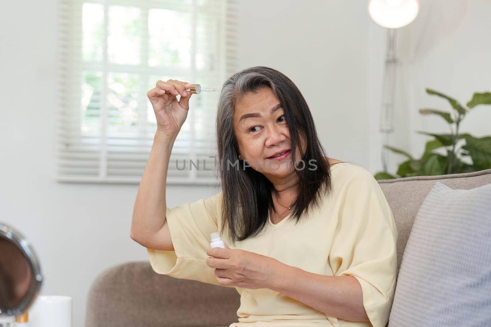 The elderly woman uses serum on her hair, reflecting her dedication to beauty and self-care, emphasizing that beauty knows no age.