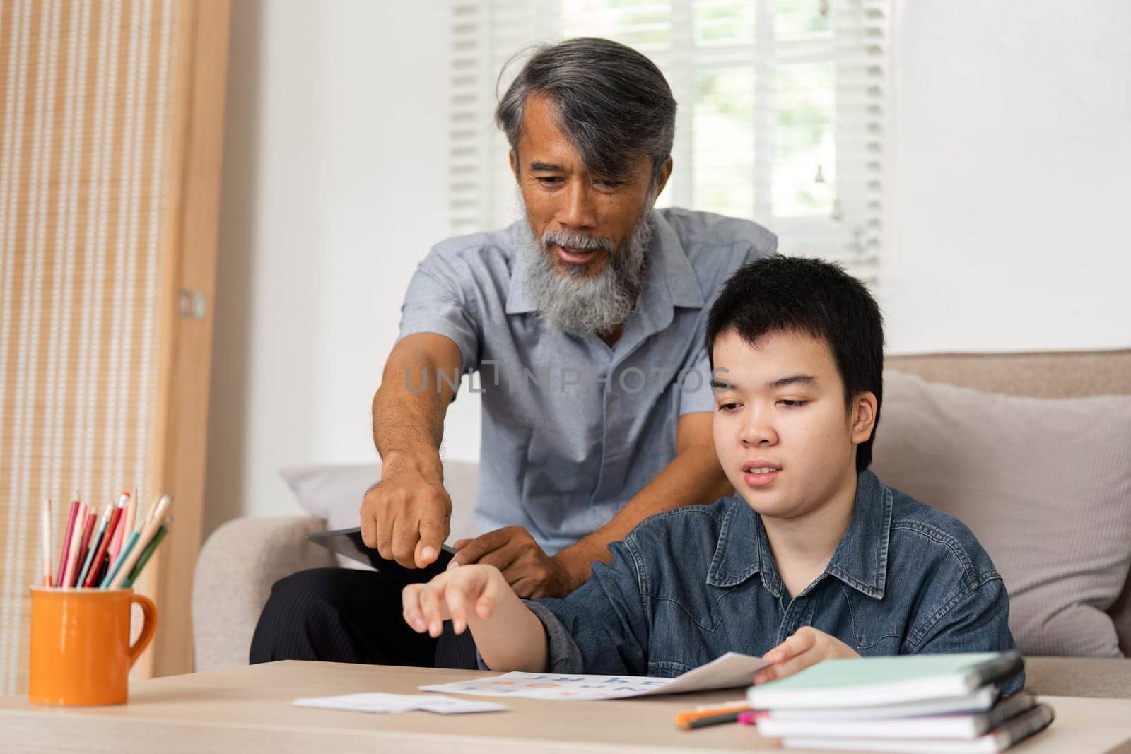 A meaningful moment where a grandfather helps his grandson with educational materials, fostering a supportive learning environment.