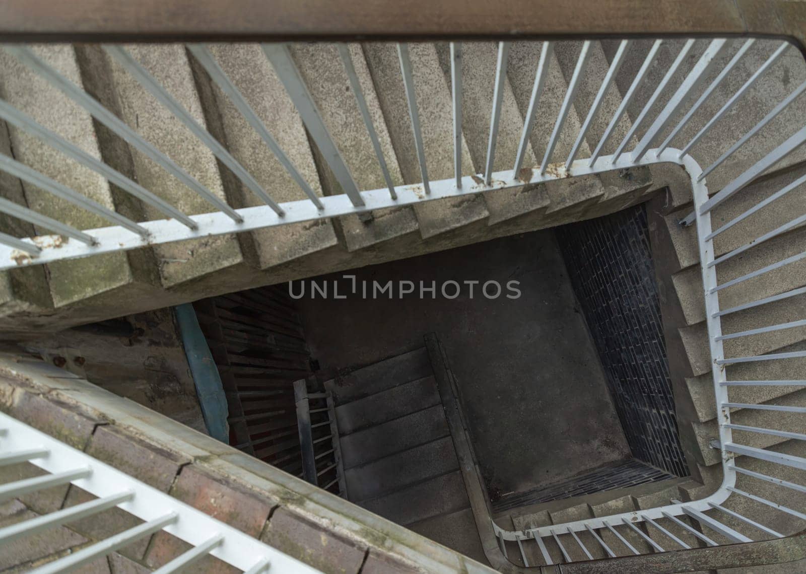 Newcastle, UK - Apr 14, 2025 - View from above of concrete spiral staircases pattern with steel handrail into Basement of the historic building architecture. use it as your Wallpaper, Poster and Copy space, Selective focus.