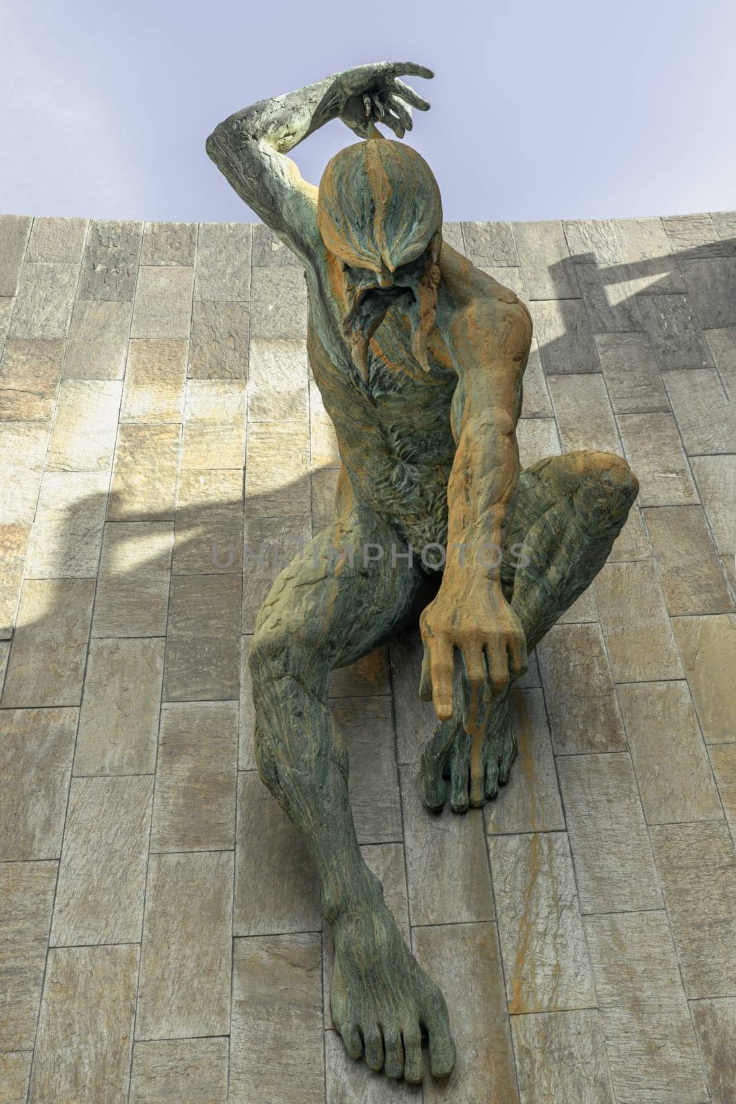 Newcastle, UK - Apr 14, 2025 - Stunning view of Bronze River God Tyne Sculpture is mounted on an external wall with blue sky background of The Newcastle Civic Centre Building at Newcastle Upon Tyne. use it as your Wallpaper, Poster and Copy space, Selective focus.