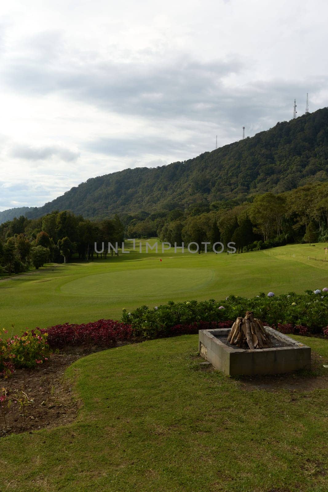A tranquil golf course scene featuring vibrant green grass, well maintained landscaping, and the serene backdrop of shadowy mountains, ideal for outdoor relaxation
