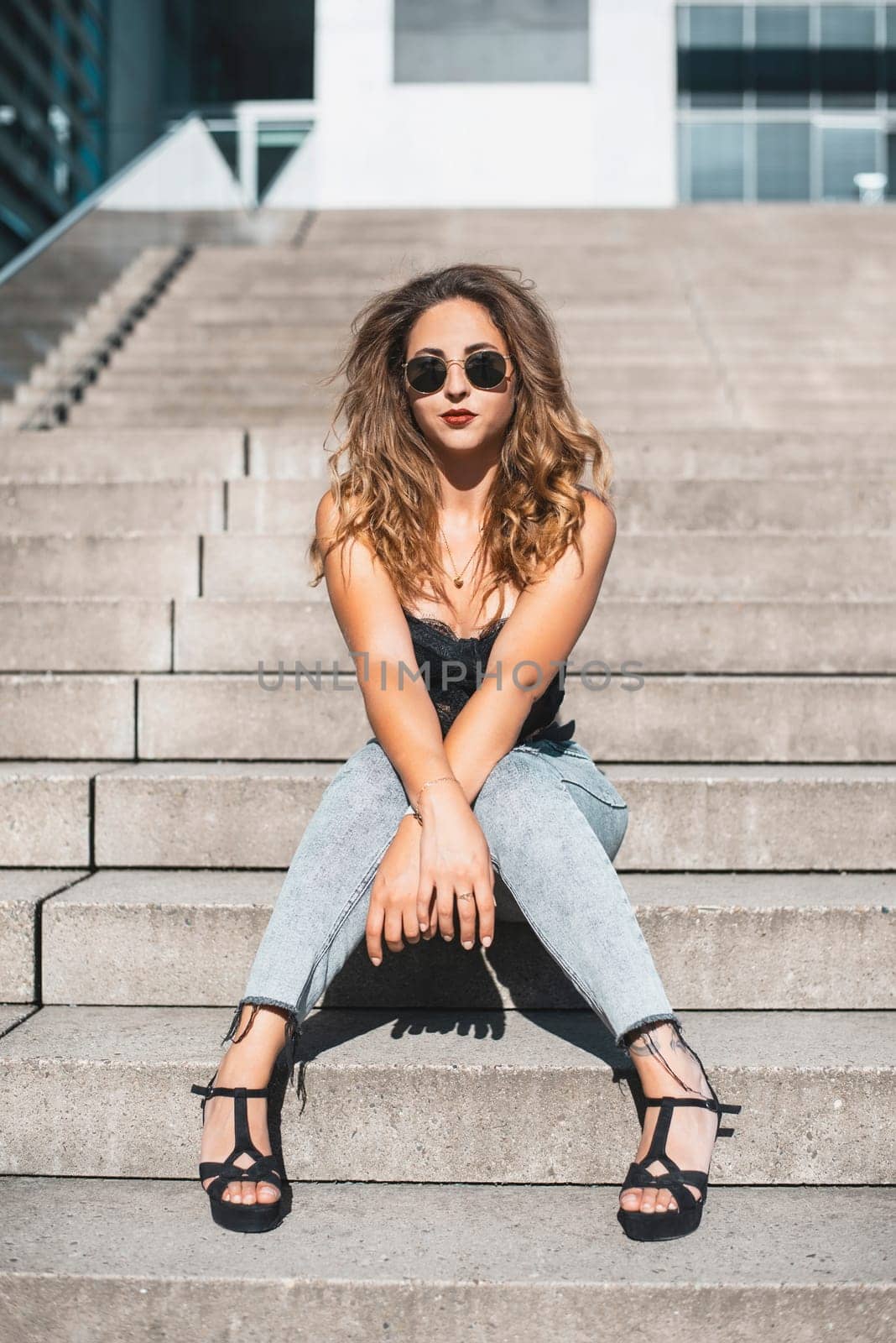 relaxed young woman sitting on a staircase in the city