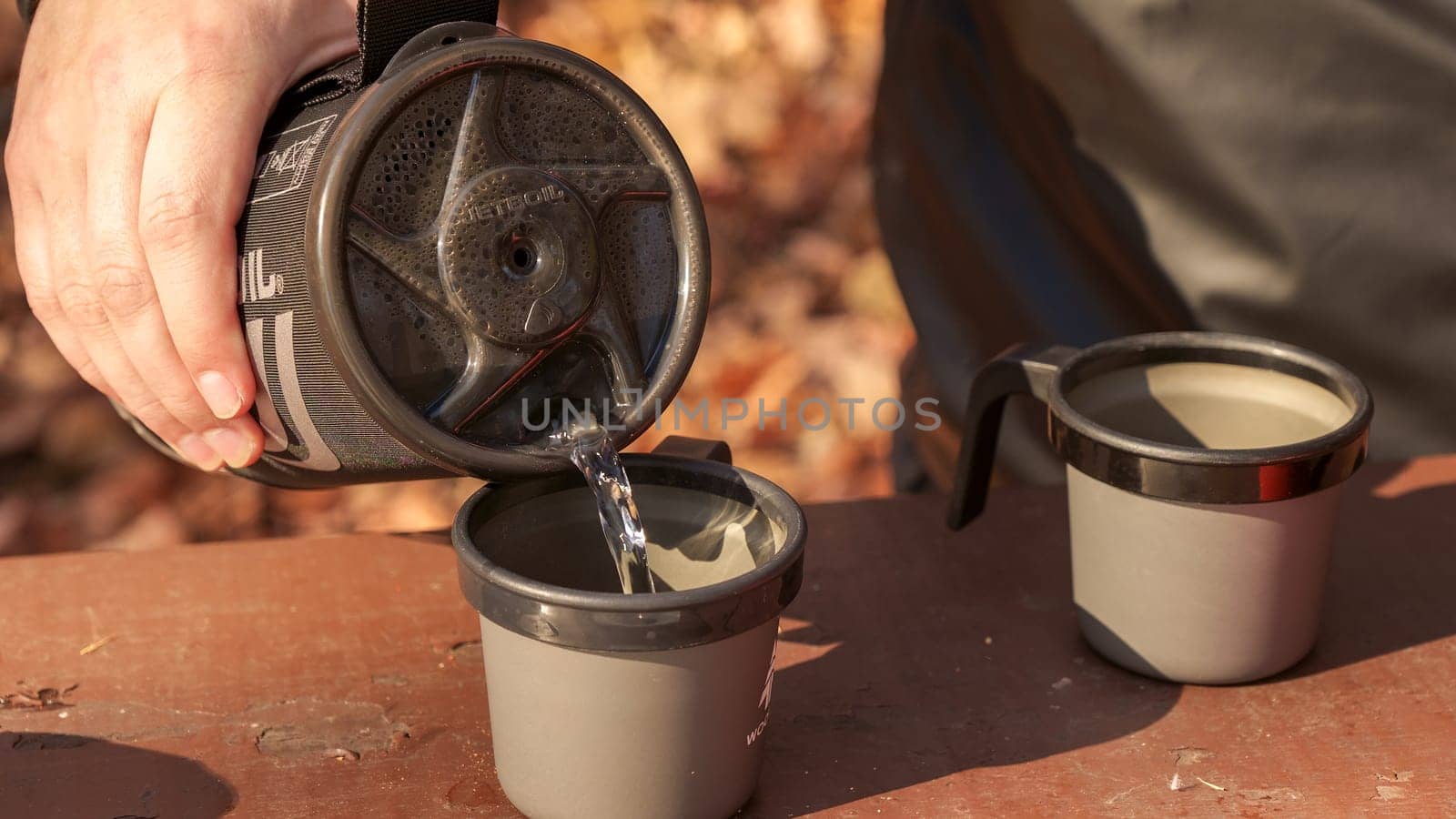 making coffee with boiling water in the autumn wooded forest while camping in an instant boil Jetboil and small gas tank. Ottawa ON Canada - 07.27.2023.