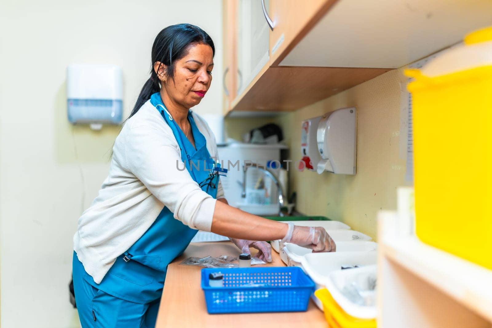 Nurse wearing gloves is preparing medication for residents in a nursing home treatment room, ensuring safety and proper dosage for elderly care