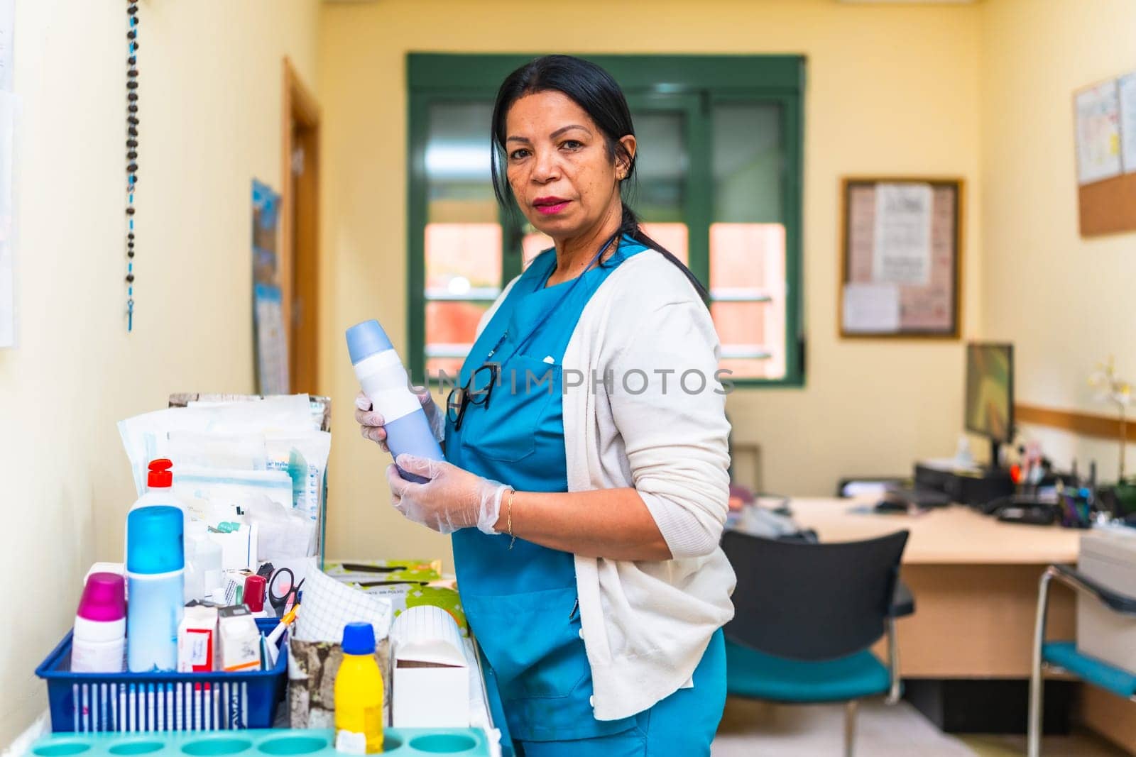 Nurse wearing gloves and holding medical equipment, preparing treatment in a nursing home