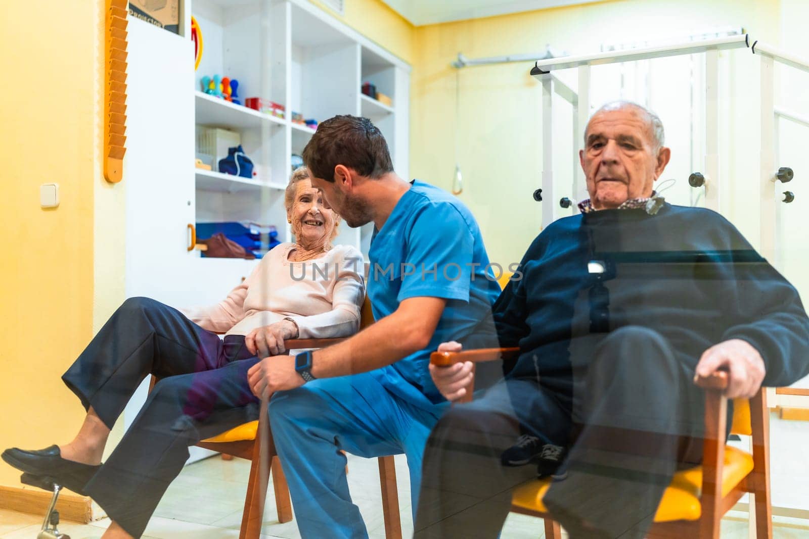 Nurse helping elderly woman with leg exercises, promoting mobility and well being in a bright nursing home environment