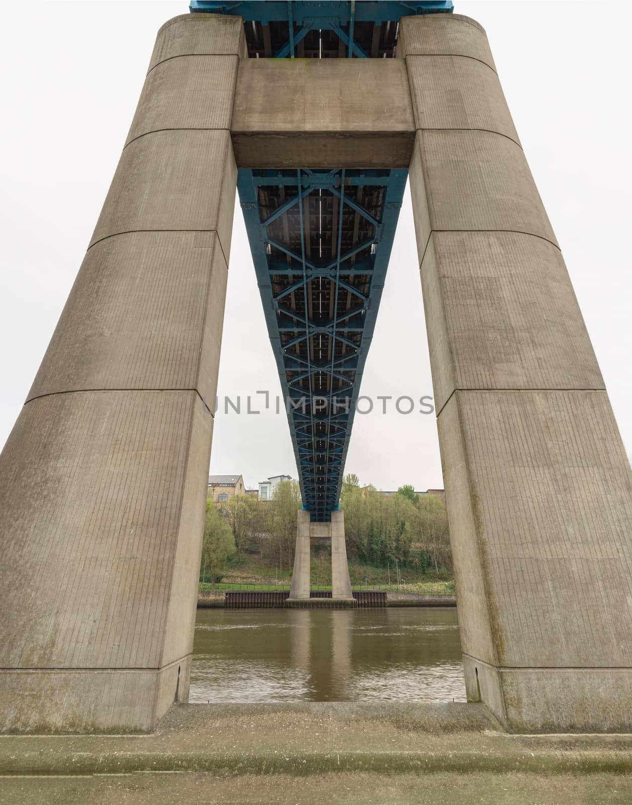 Newcastle, UK - Apr 12, 2025 - Perspective of Foundation concrete pillars abutment and Steel truss construction with fabricated box chords of The Queen Elizabeth II Bridge. is carries the Tyne and Wear Metro between Newcastle upon Tyne and Gateshead over the River Tyne in North East England. The line is in tunnels on either side of the river and only emerges into open air to cross the bridge, use it as your Wallpaper, Poster and Copy space, Selective focus.