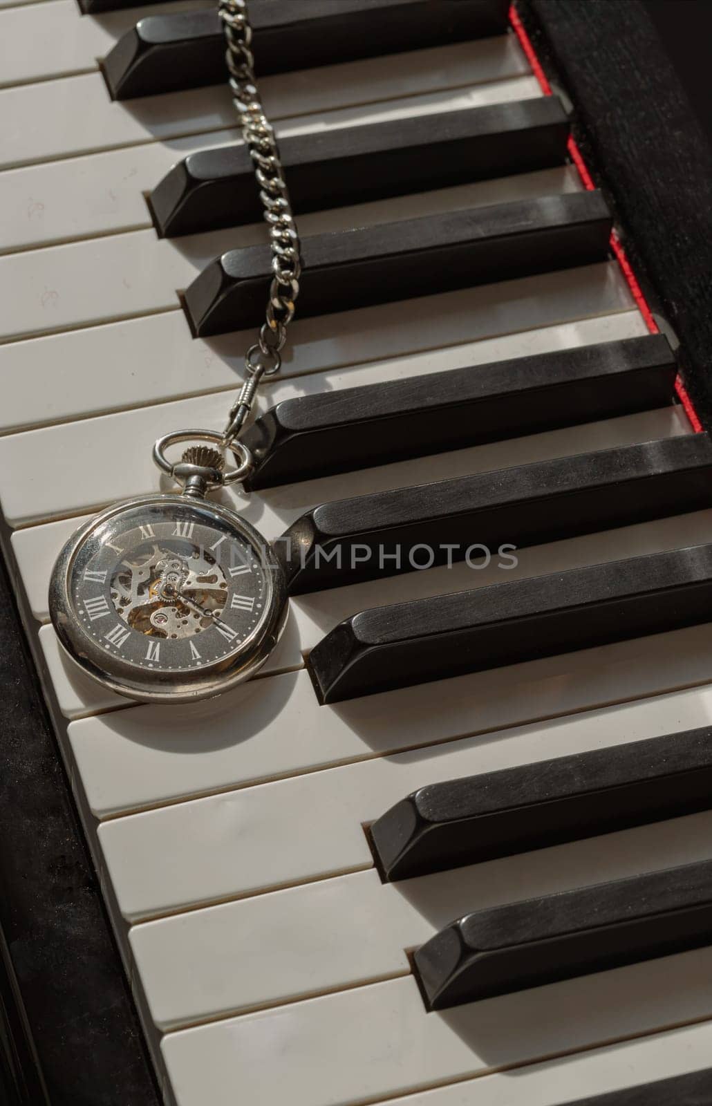 London, UK - Apr 19, 2025 - Antique pocket watch or Retro pocket watch on Piano keys background. "keys and time" use it as your Wallpaper, Poster and Space for text, Selective focus.