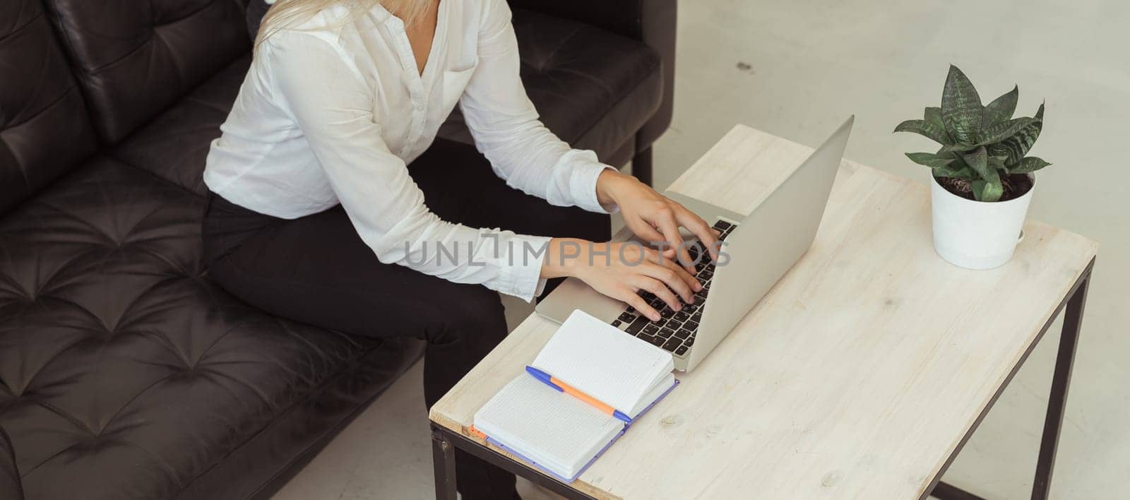 Banner Businesswoman working remotely with laptop at home. Freelance, productivity and digital lifestyle concept. Copy space.