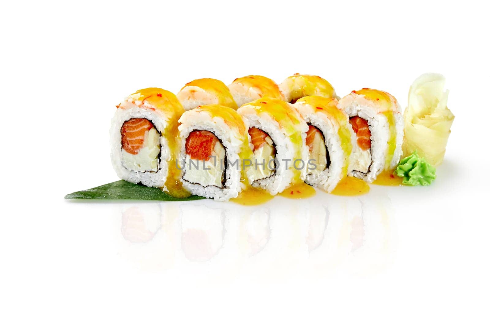 Uramaki sushi rolls filled with salmon, cream cheese and crab meat, covered with mango sauce, garnished with pickled ginger and wasabi