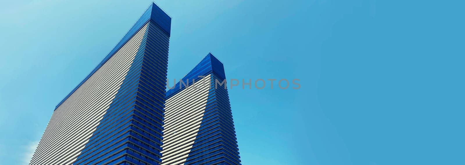 Modern architecture, high-rise residential building, house with glass facade on blue sky background