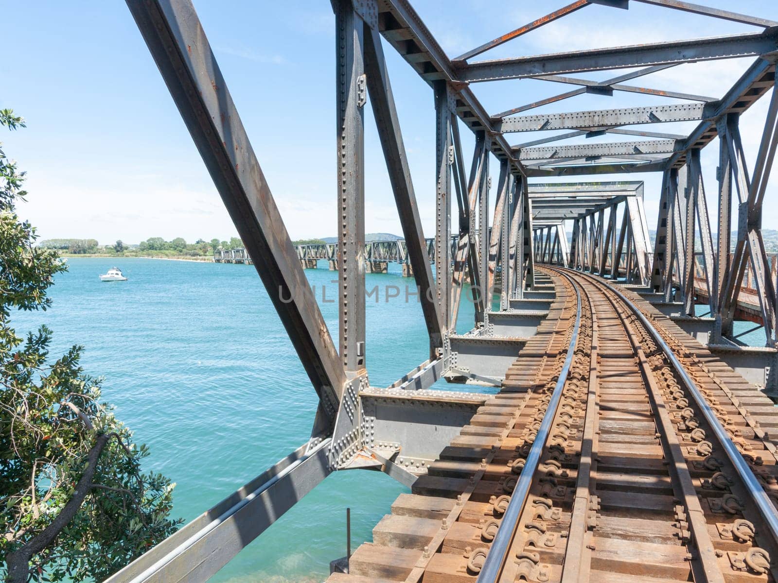 Tauranga historic railway bridge crossing harbour with leading lines of railway tracks.