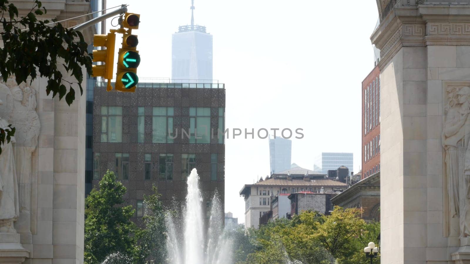 New York City, United States - 8 Sep 2023: Street crossroad, yellow traffic light, transport road intersection, United States. Washington Square Arch and fountain. World Trade Center. 5 Fifth Avenue.