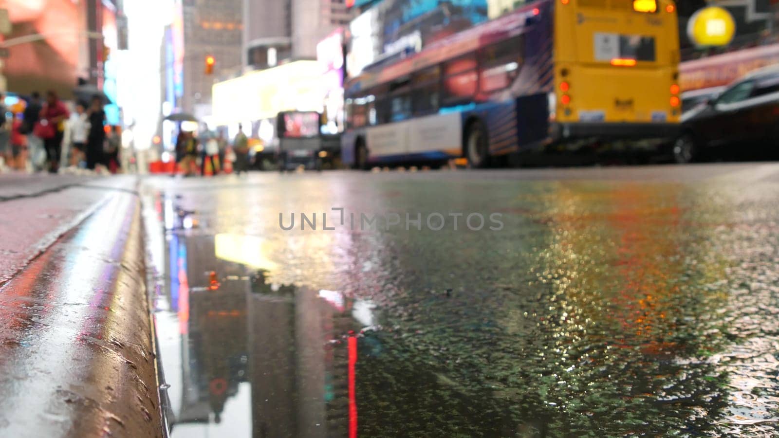 New York City, United States - 10 Sept 2023: Times Square, Manhattan Midtown Broadway street, USA. Wet american urban road, autumn rainy day, traffic defocused. People. Commercial billboard screens.