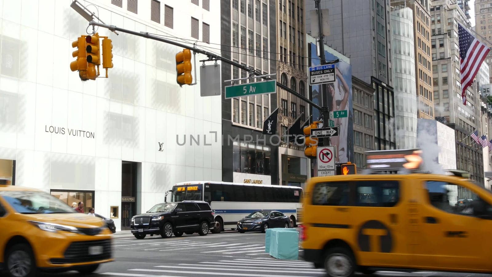 New York City, United States - 13 Sept 2023: Manhattan Midtown street, Fifth 5 avenue. American urban road car traffic. Yellow taxi in USA. People. Boutique fashion stores for shopping. Louis Vuitton