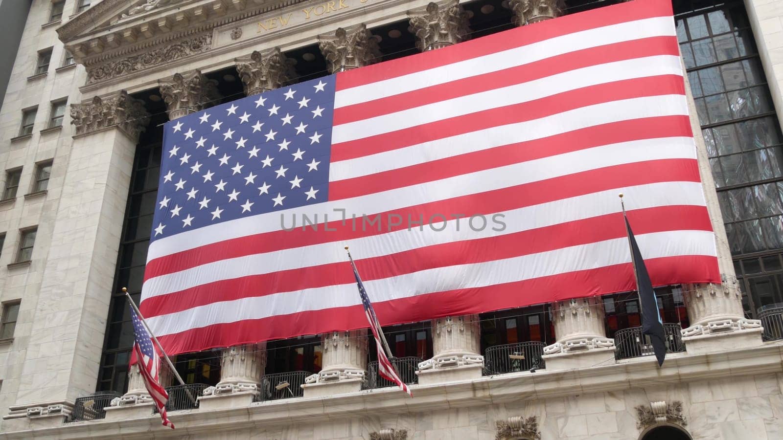 New York City, United States - 9 Sept 2023: Lower Manhattan Downtown Financial District urban architecture. Huge big American flag. Wall street Stock Exchange building, USA Stock Market trading.