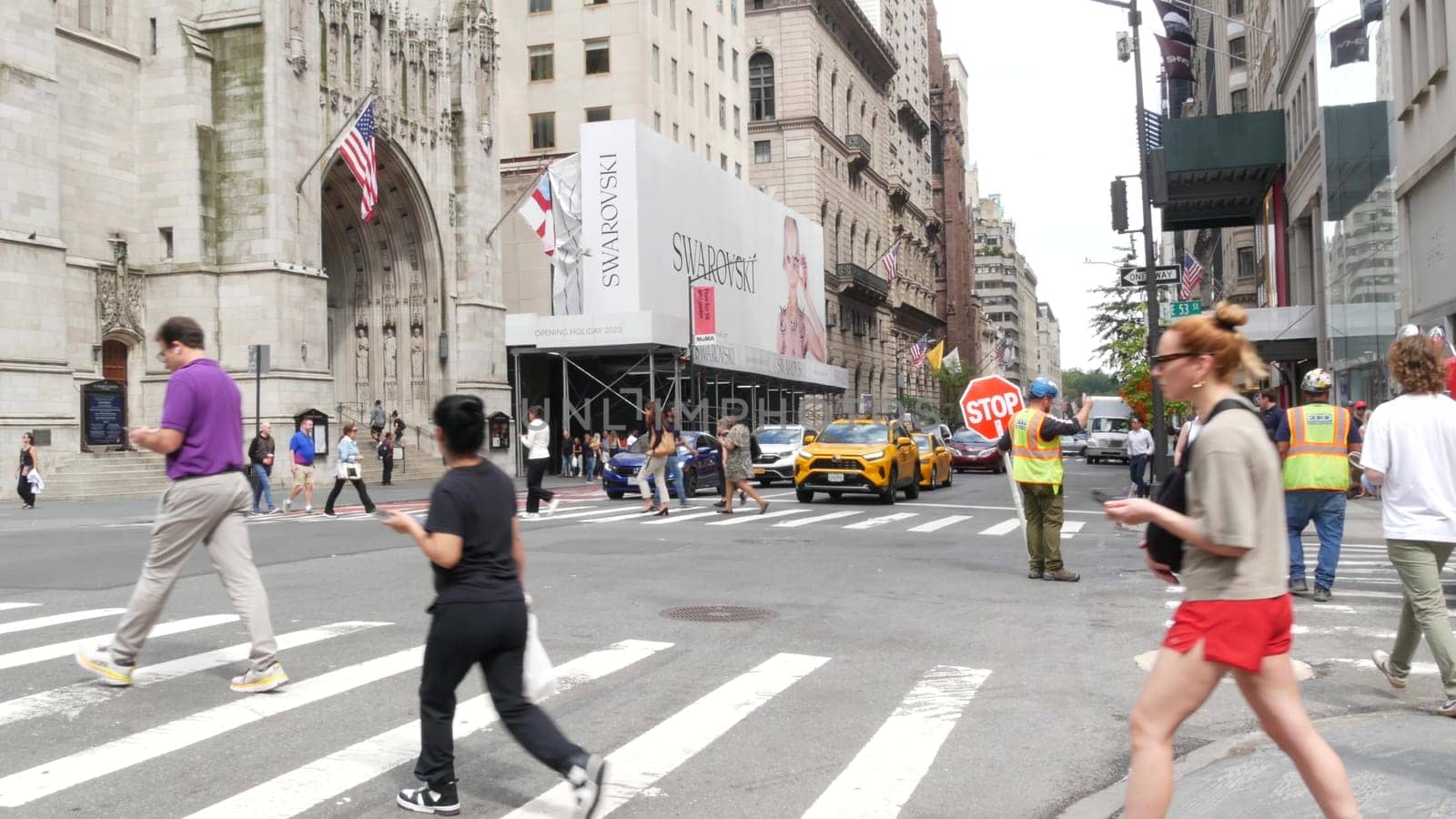 New York City, United States - 11 Sept 2023: Manhattan Midtown street, Fifth 5 avenue, 5th ave, American road car traffic, Yellow taxi cab. People pedestrians, zebra crosswalk, crossroad intersection.