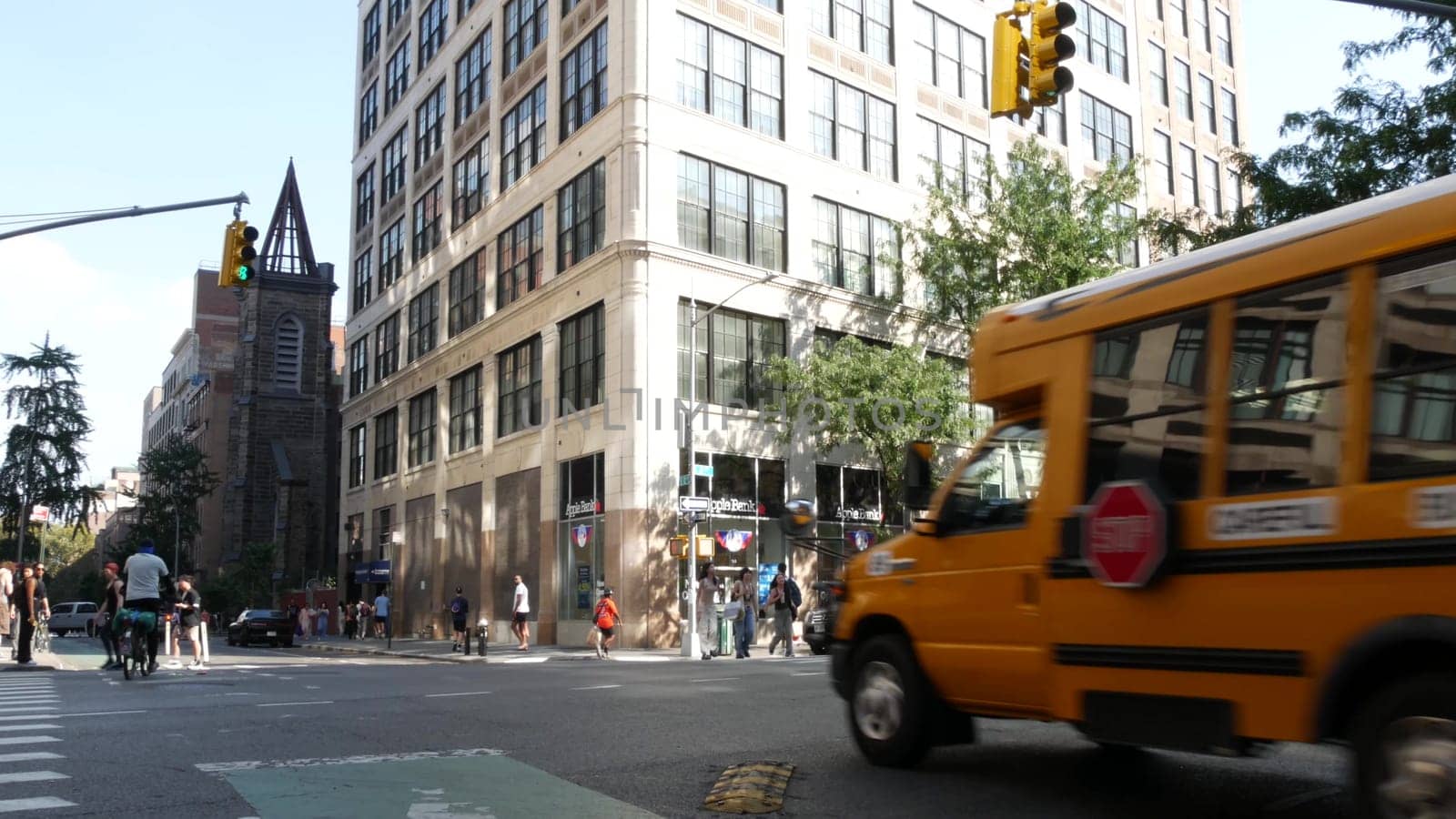 New York City, United States - 6 Sept 2023: Yellow School Bus on Manhattan street, schoolbus, taxi and police car on avenue. Children education, road transportation, NYPD USA. American school shuttle.