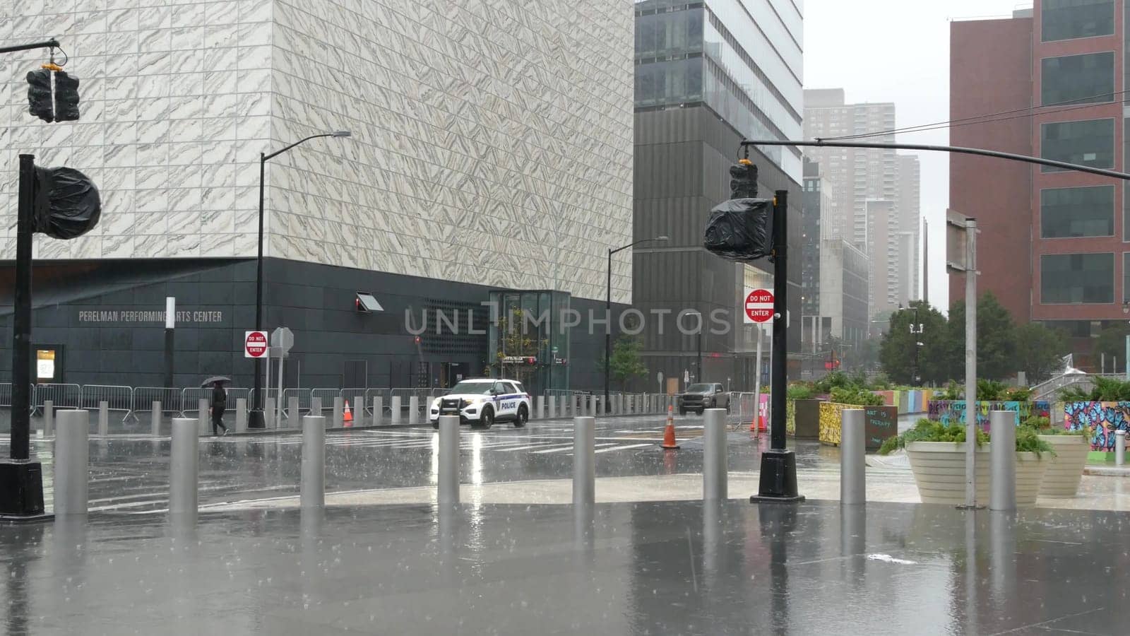 New York City, United States - 10 Sept 2023: Manhattan Downtown Financial District. People with umbrella on rainy day. World Trade Center Oculus, memorial pools and 911 Museum area, Greenwich street.