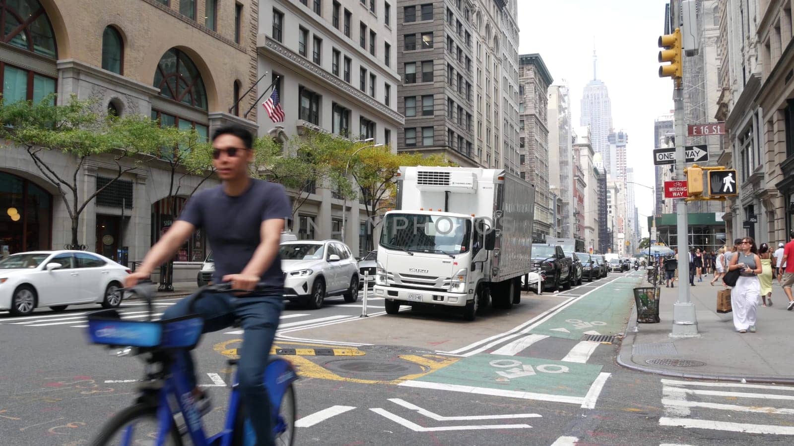 New York City, United States - 8 Sept 2023: Manhattan Midtown street, Fifth 5 avenue. American urban road car traffic, USA. People pedestrians, Empire State Building. UPS brown delivery truck, DHL van