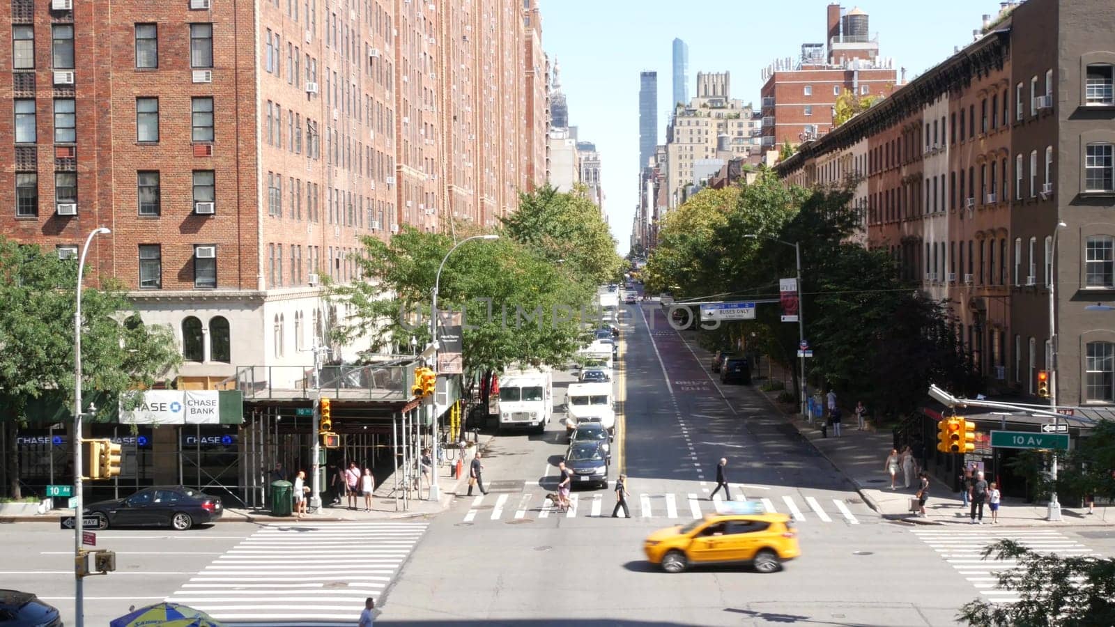 New York City, United States - 1 Sept 2023: Chelsea urban architecture from High Line, Manhattan Midtown street, 10 avenue. American red brick residential buildings, cars traffic on road, yellow taxi.