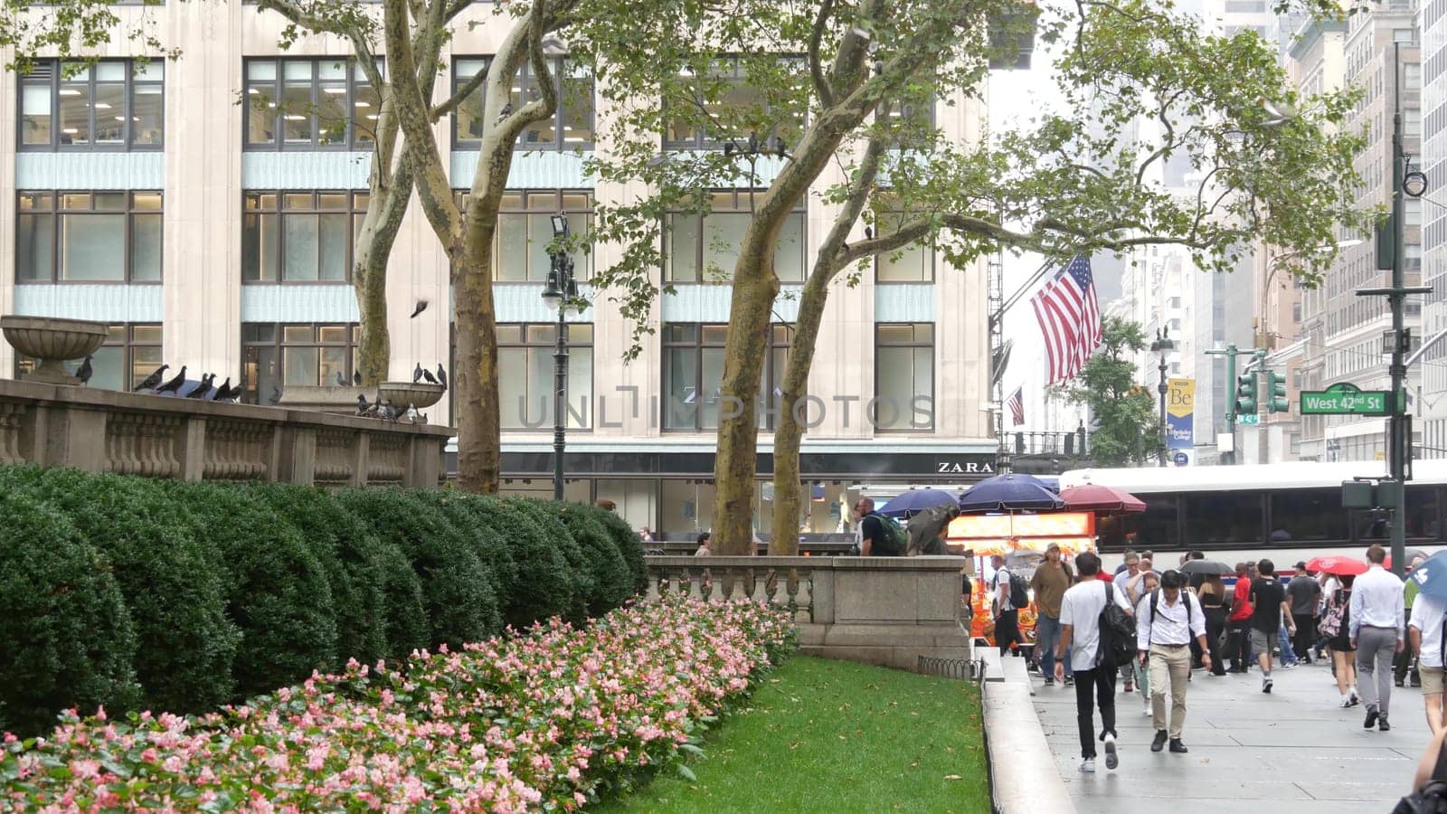 New York City, United States - 13 Sept 2023: Manhattan Midtown, Fifth 5 avenue. 42 street intersection corner near Bryant Park and Library, USA. American urban traffic, people pedestrian on rainy day.