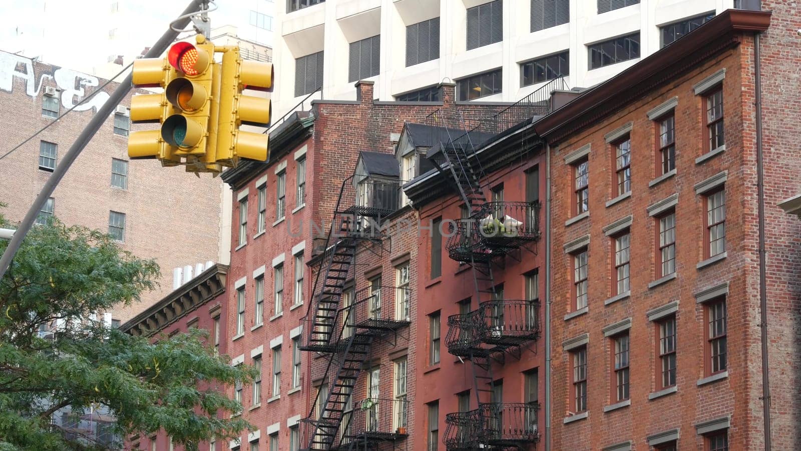 New York City, United States - 31 Aug 2023: Street crossroad, traffic light, transport road intersection. Residential building. Red brick house, fire ladder. Manhattan downtown financial district FiDi
