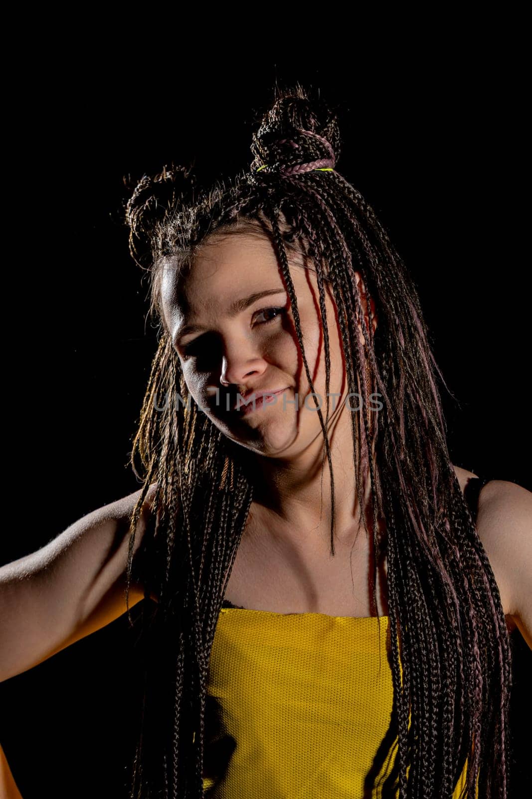 A stylish and fashionable model elegantly showcases a striking and eyecatching hairstyle against a dark backdrop