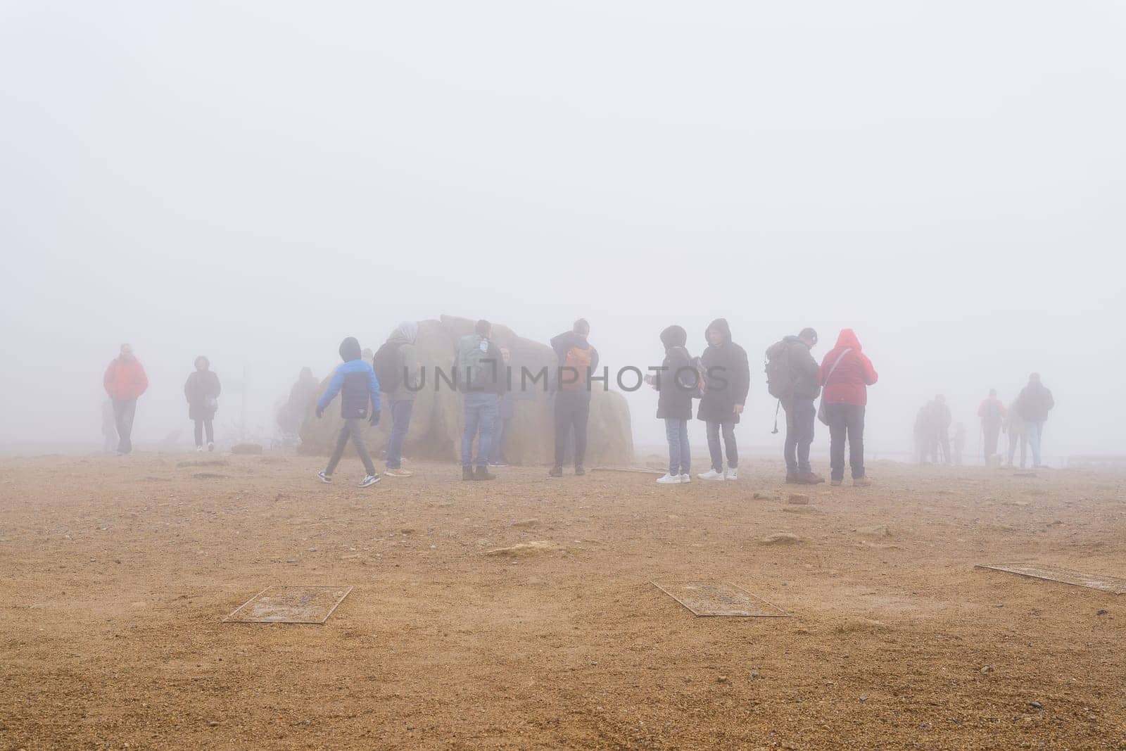Wernigerode, Germany – October 31, 2024: Hikers on the summit of the Brocken in the Harz National Park on a foggy day in fall
