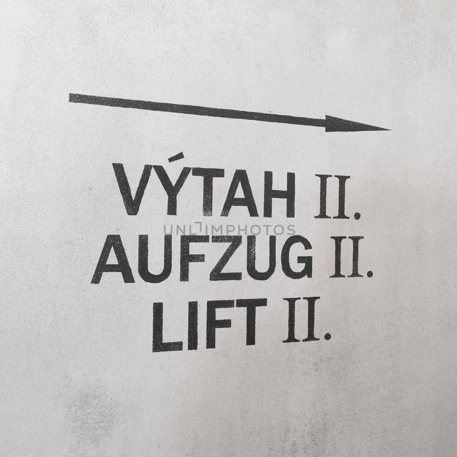 Directional arrow pointing to an elevator in Czech, German and English language