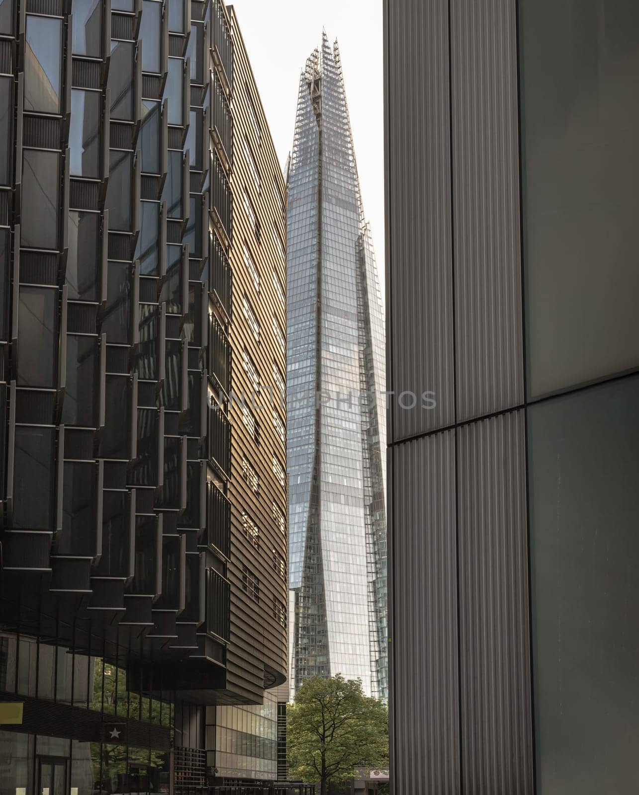London, UK - Apr 27, 2025 - Perspective of Alley with The Shard skyscraper and some of the modern glass buildings exterior in more london riverside. use it as your Wallpaper, Poster and Space for text, Selective focus.