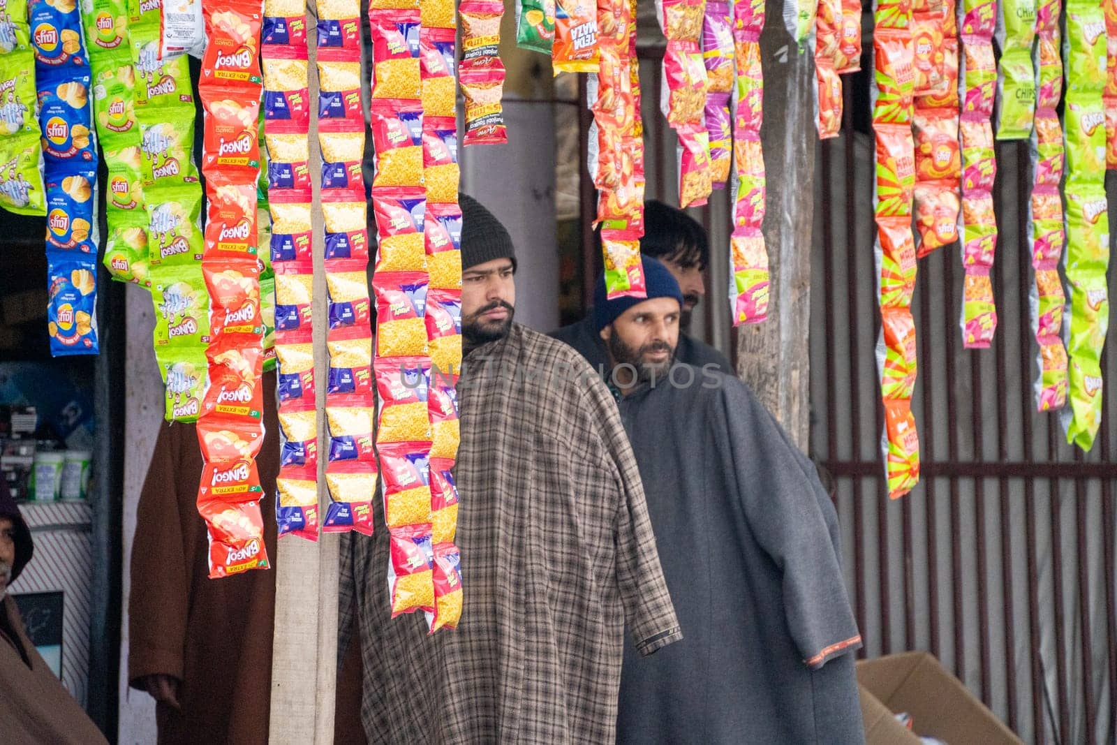 Srinagar, Kashmir - 4th Jan 2025: Young Indian salesmen customers standing at a local shop peering in between food packages showing the retail presence in Jammu